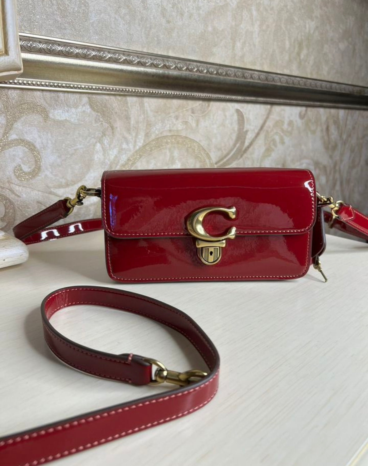 Heritage Compact Shoulder Bag in Glossy Crimson with Sculpted Gold Emblem