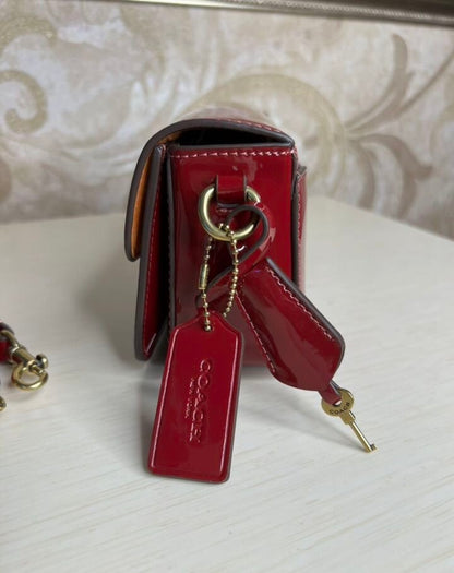 Heritage Compact Shoulder Bag in Glossy Crimson with Sculpted Gold Emblem