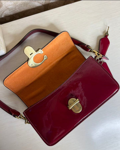 Heritage Compact Shoulder Bag in Glossy Crimson with Sculpted Gold Emblem
