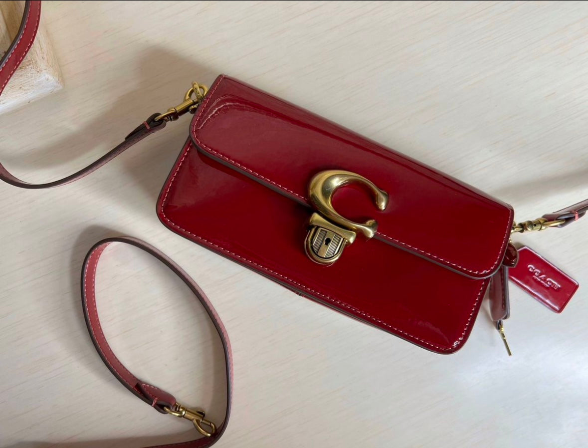 Heritage Compact Shoulder Bag in Glossy Crimson with Sculpted Gold Emblem