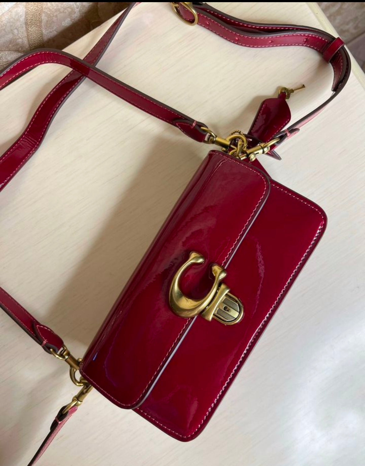 Heritage Compact Shoulder Bag in Glossy Crimson with Sculpted Gold Emblem